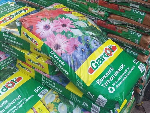 Blumenerden enthalten häufig Torf. Ein Sack Blumenerde im Baumarkt.
