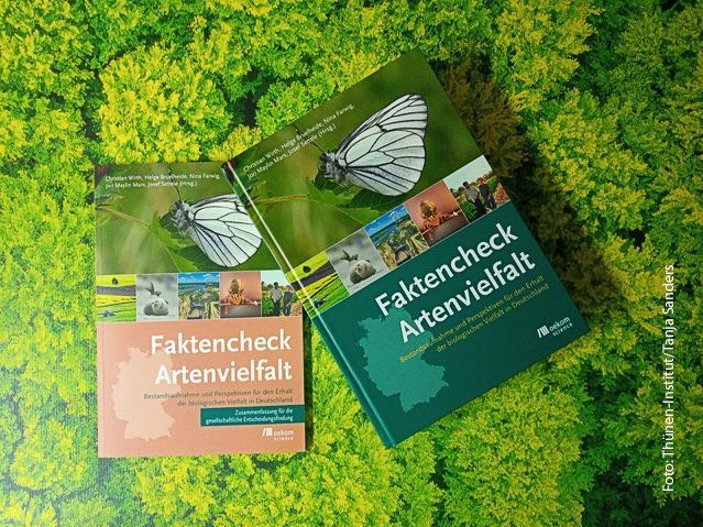 Zwei Bücher liegen auf grünem Untergrund. Buchtitel: Faktencheck Artenvielfalt.