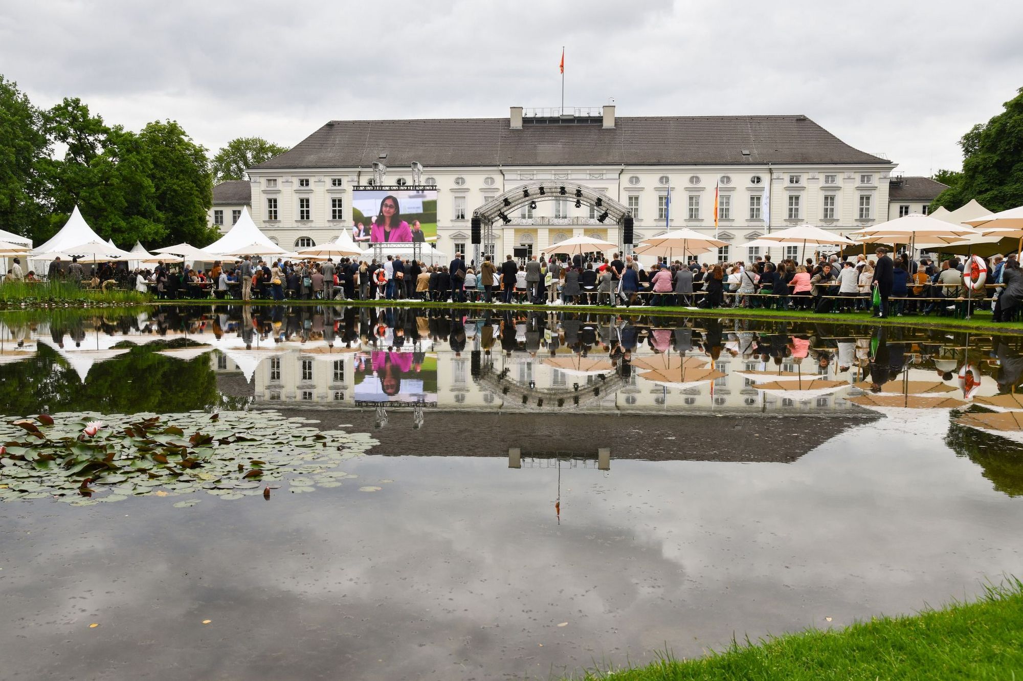 Schloss Bellevue mit den Pavillons der Woche der Umwelt spiegelt sich im See 