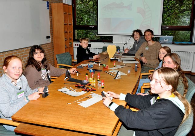 Eine Gruppe Schüler bauen einen bionischen Greifer aus Papier