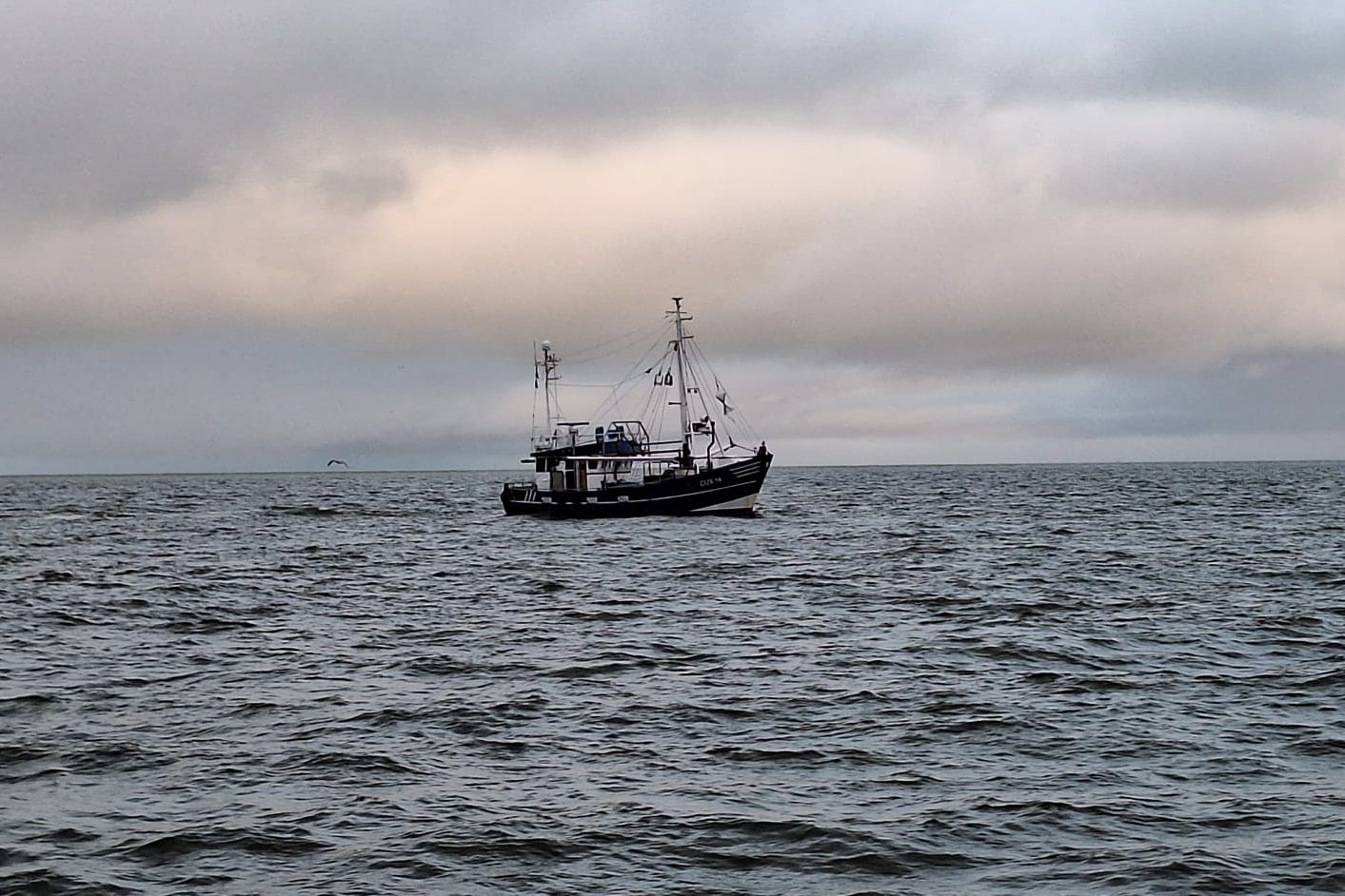 Ein kleines Schiff fährt vorbei.