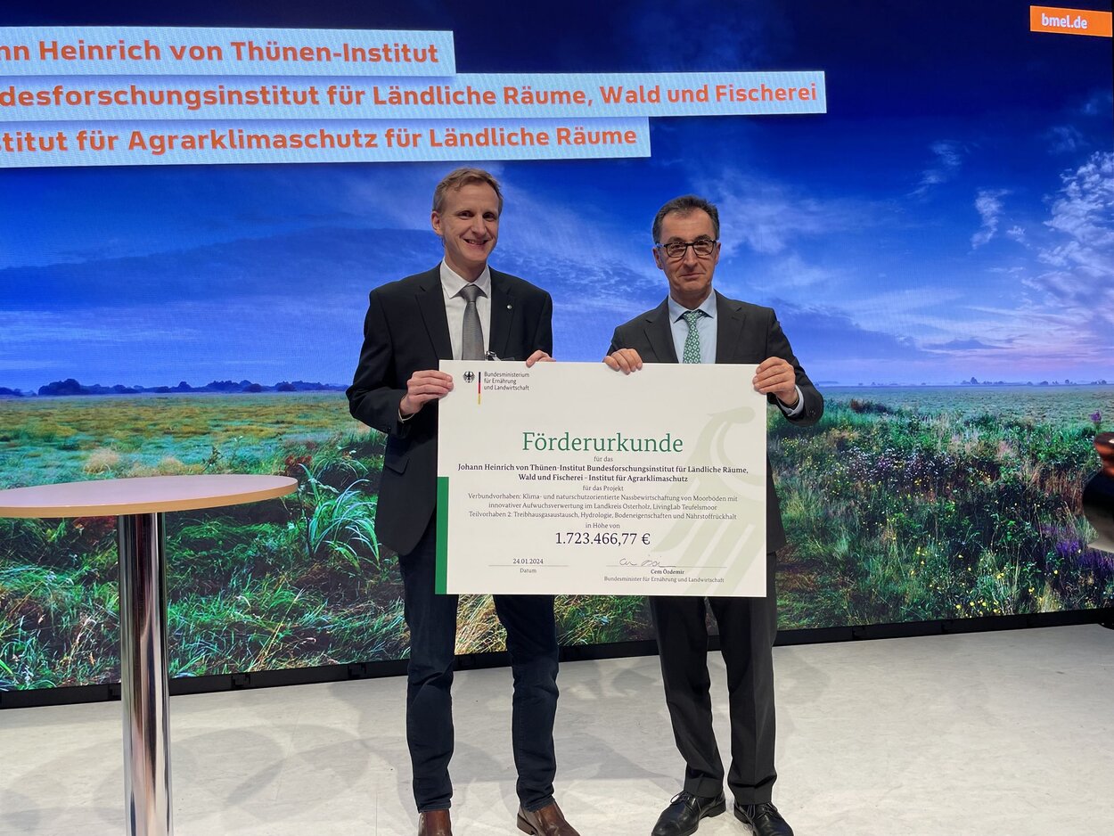 Bundesminister für Ernährung und Landwirtschaft Cem Özdemir übergibt den Förderbescheid an Christian Brümmer