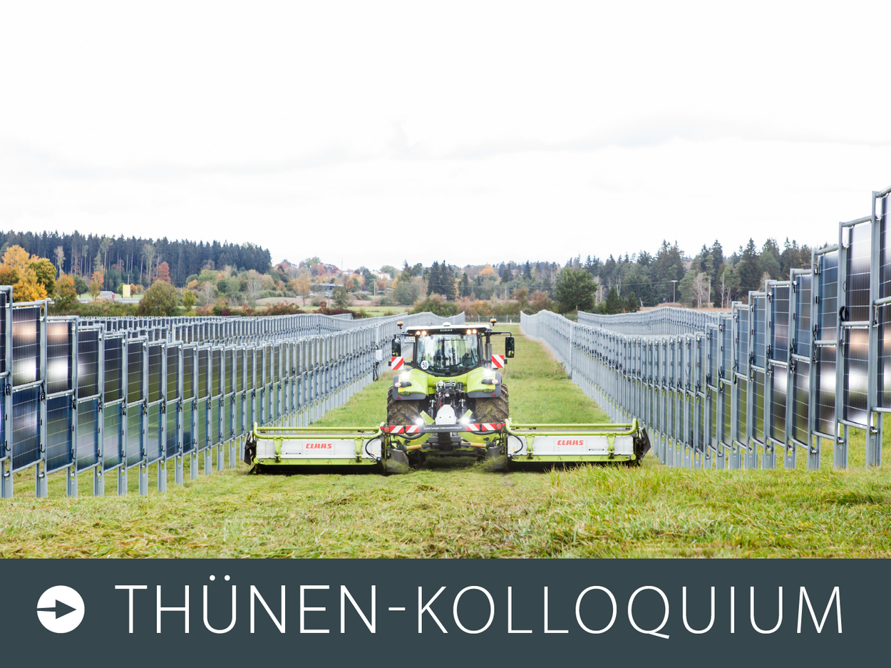 Ein Trecker mit Mähwerk fährt zwischen senkrecht stehenden Photovoltaiikreihen durch