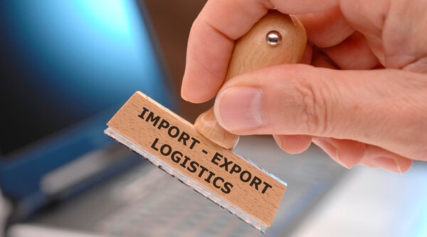 The current customs policy stems from a supposedly unfair balance of trade. A wooden stamp with the inscription Export, Import, Logistics.