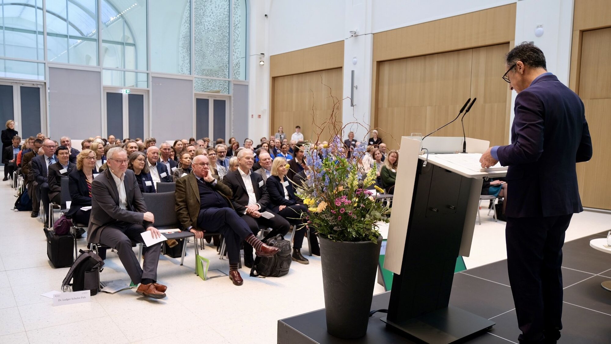 Grußwort von Bundesminister Cem Özdemir. Blick in den Tagungsraum, der Bundesminister steht am Rednerpult.