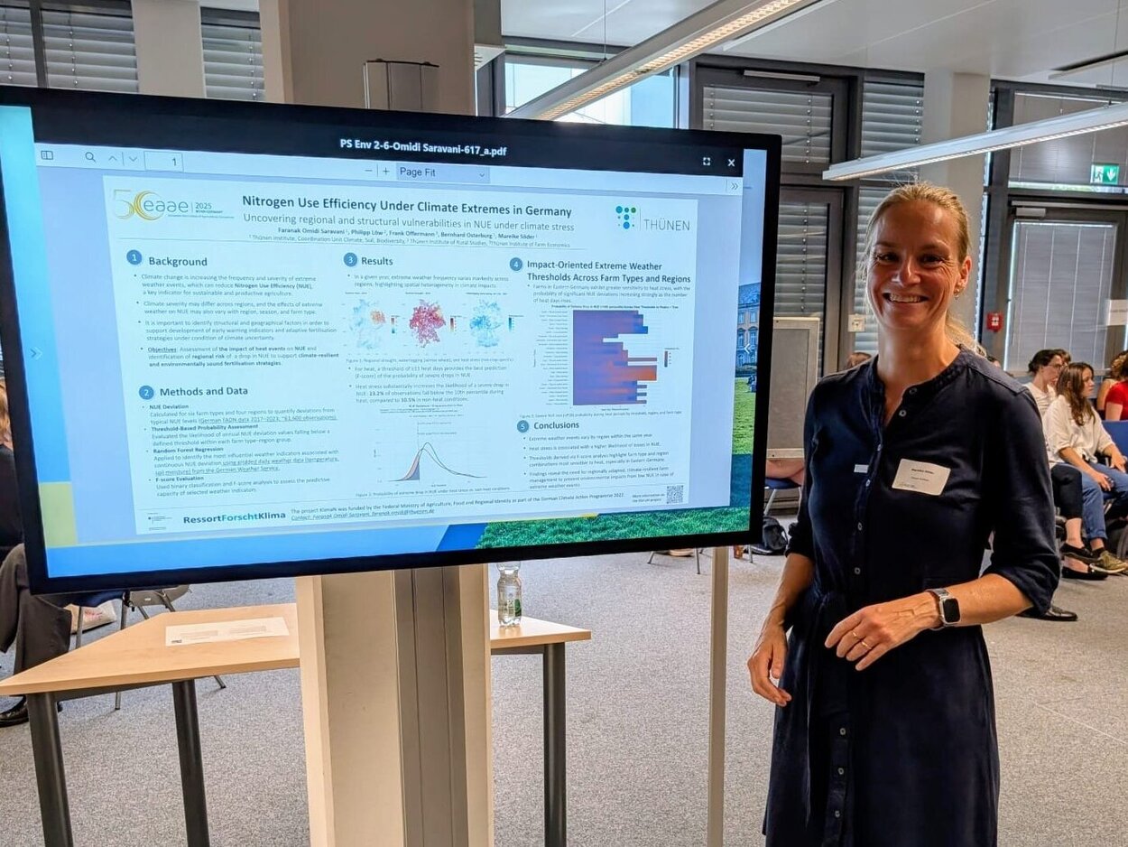Posterpreis für die Stabsstelle Klima, Boden, Biodiversität. Eine Person steht vor einem großen Monitor auf dem ein Poster präsentiert wird.