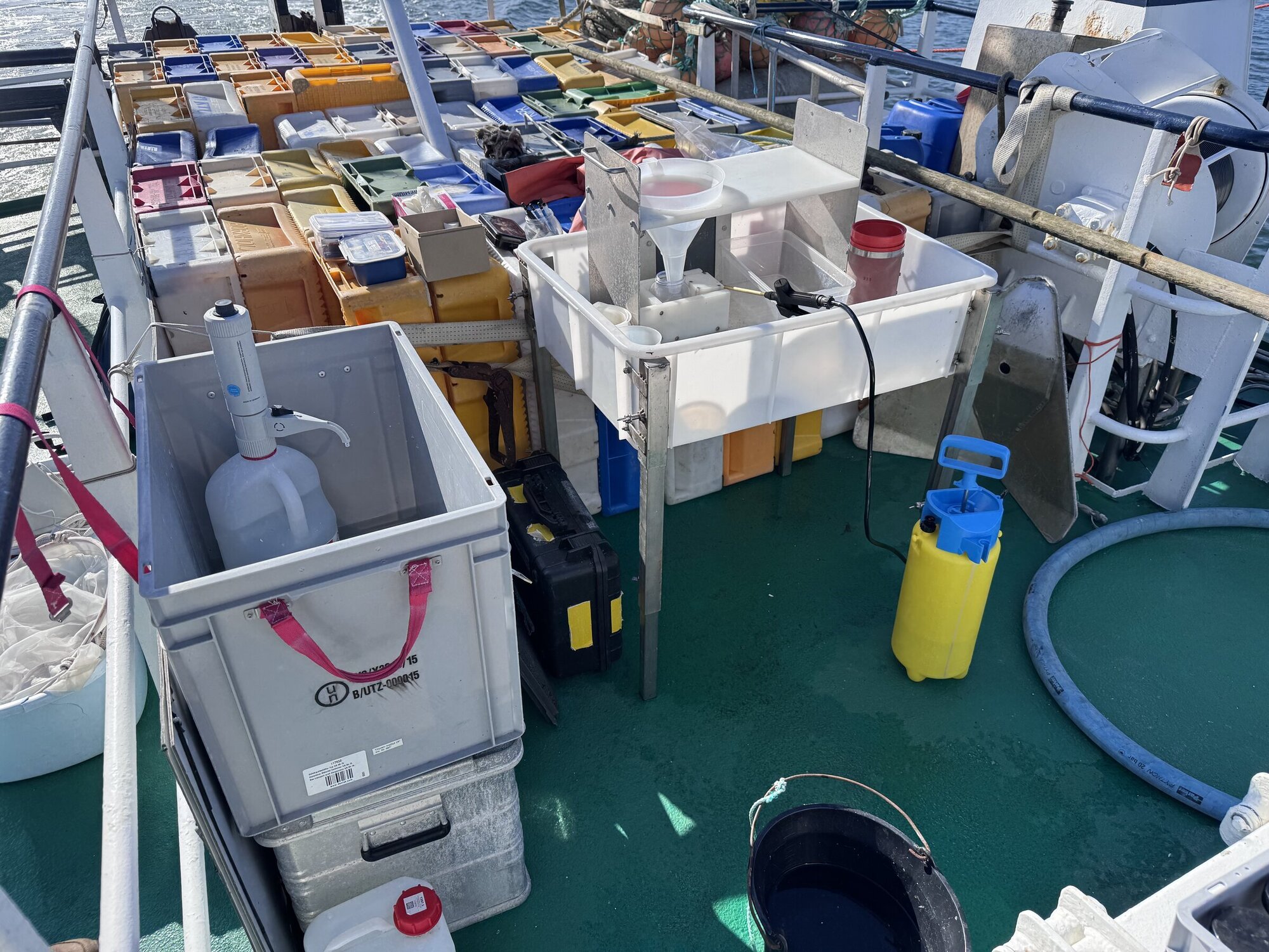 Improvisierter Arbeitsplatz für das Abfüllen der Planktonfänge auf dem Deck der „Crampas“. Verschiedene Arbeitsutensilien auf einem Schiffsdeck zum Abfüllen von Planktonproben.
