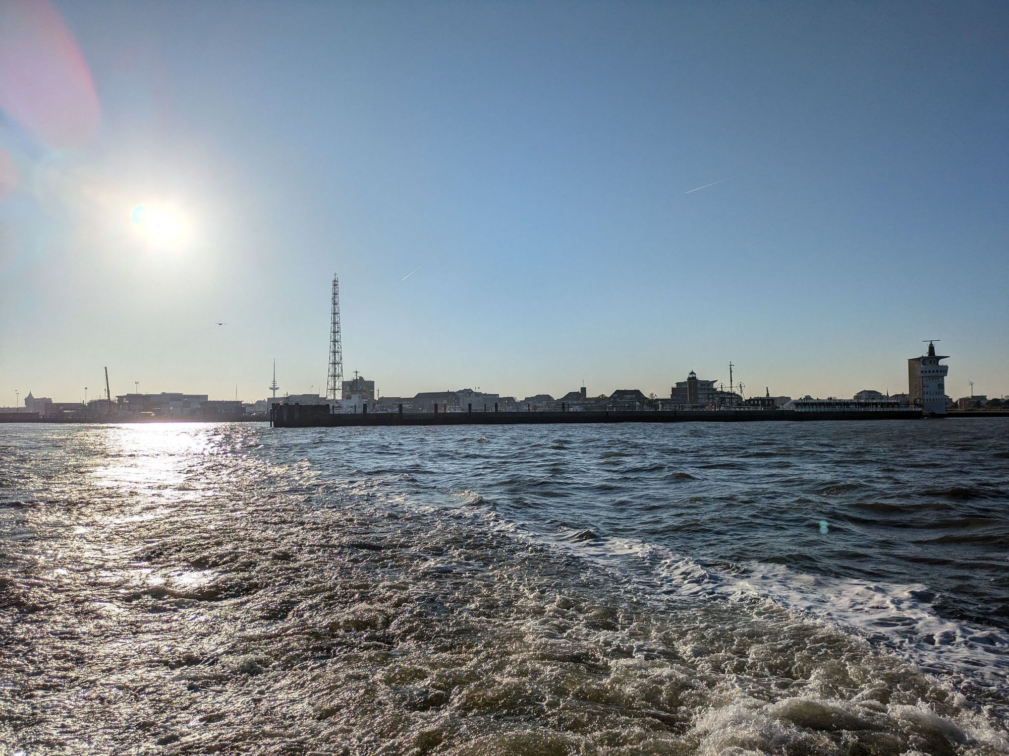 Schäumendes Kielwasser der Solea vor der Hafensilhouette