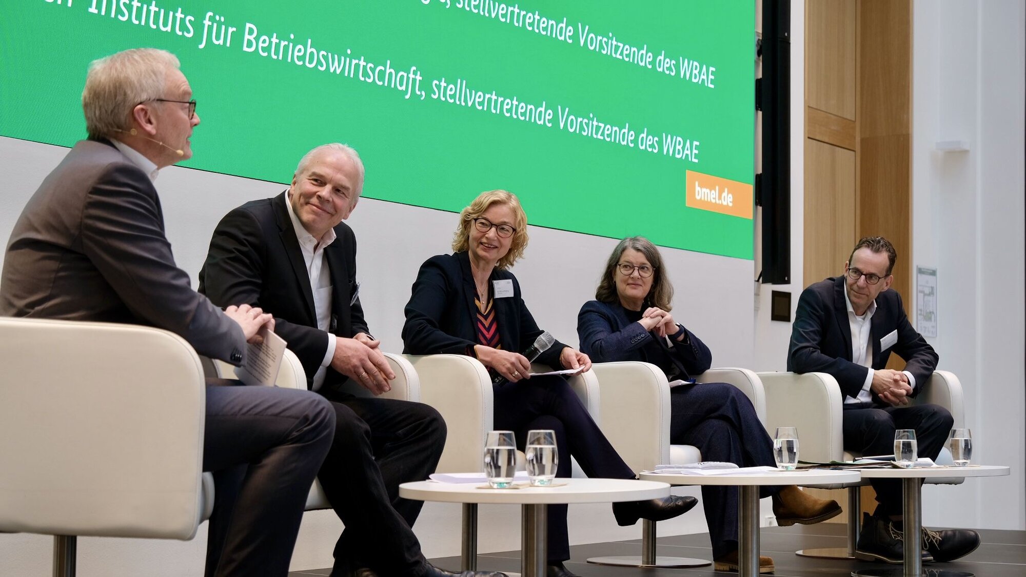 Diskussionsrunde unter Leitung von Dr. Ludger Schulze Pals mit Prof. Dr. Harald Grethe, Prof. Dr. Hiltrud Nieberg, Prof. Dr. Britta Renner, Prof. Dr. Achim Spiller (v.l.n.r.). Mehrer Personen sitzen auf Sesseln auf einer Bühne.