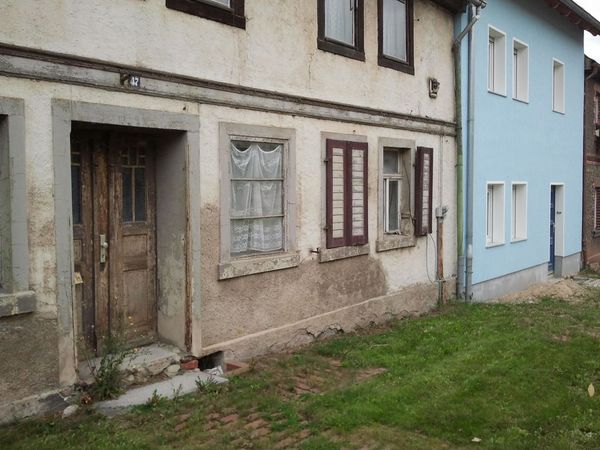 Das Bild zeigt ein altes und ein frisch renoviertes Haus als Beispiel für die unterschiedliche Entwicklung auf engstem Raum