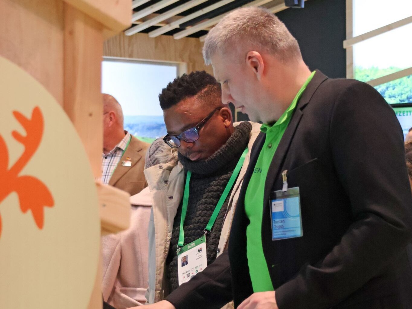 Internationaler Besuch beim Thünen-Landatlas ‒ hier ein Teilnehmer der südafrikanischen Delegation mit Thorsten Osigus vom Thünen-Institut für Lebenverhältnisse in ländlichen Räumen. Zwei Personen am Messestand