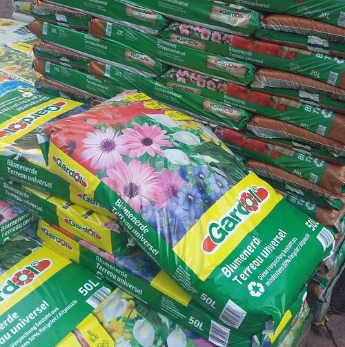 Blumenerden enthalten häufig Torf. Ein Sack Blumenerde im Baumarkt.