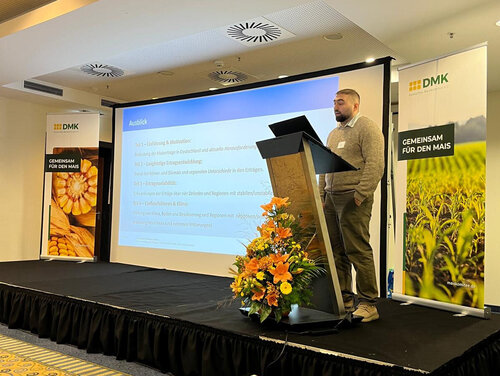 Maiskomitee Auf dem Maiskomitee ist Masud Heydarli auf einem Rednerpult zu sehen.