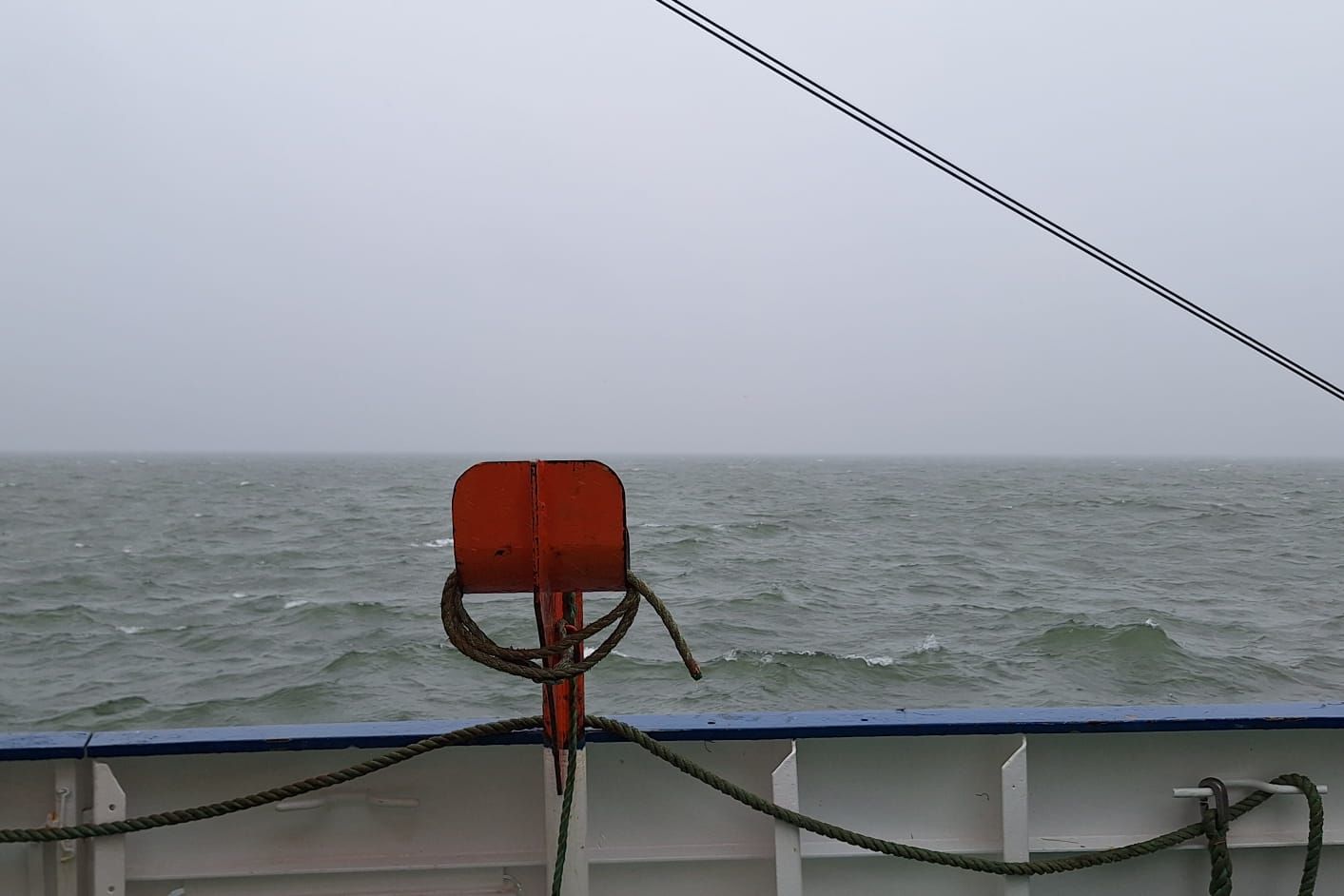 Blick von der Bordwand auf das Wasser mit einer grauen Nebelwand.