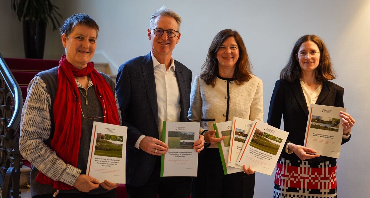 Übergabe von drei Stellungnahmen an Dr. Ophelia Nick (2. v.re.) durch die Mitglieder des WBBGR Prof. Maria Finckh, Prof. Peter Feindt und Prof. Inga Schleip. Vier Personen halten die ausgedruckten Stellungnahmen in der Hand.