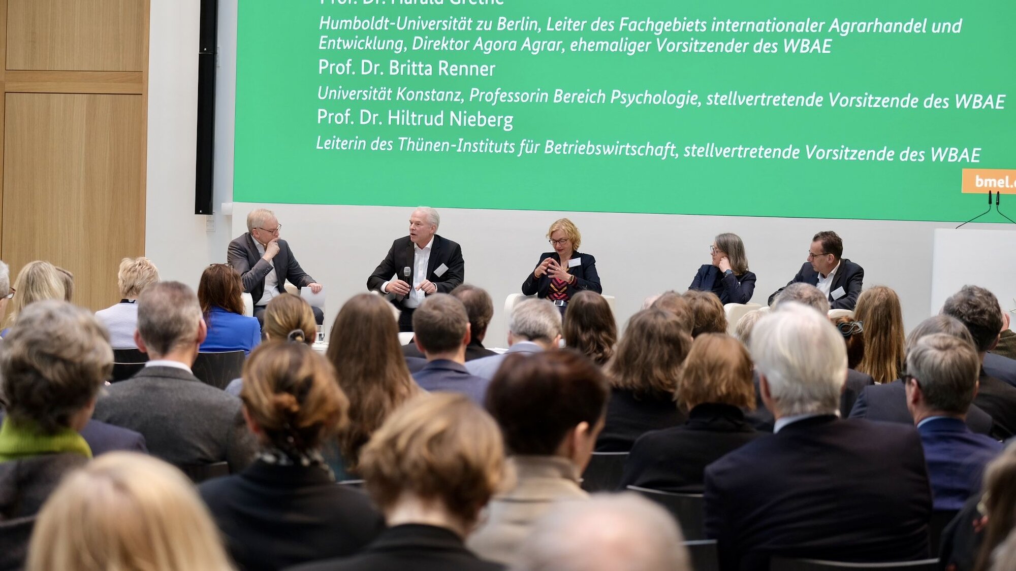 Diskussionsrunde unter Leitung von Dr. Ludger Schulze Pals mit Prof. Dr. Harald Grethe, Prof. Dr. Hiltrud Nieberg, Prof. Dr. Britta Renner, Prof. Dr. Achim Spiller (v.l.n.r.). Mehrere Personen sitzen auf Sesseln auf der Bühne, im Vordergrund das Publikum.