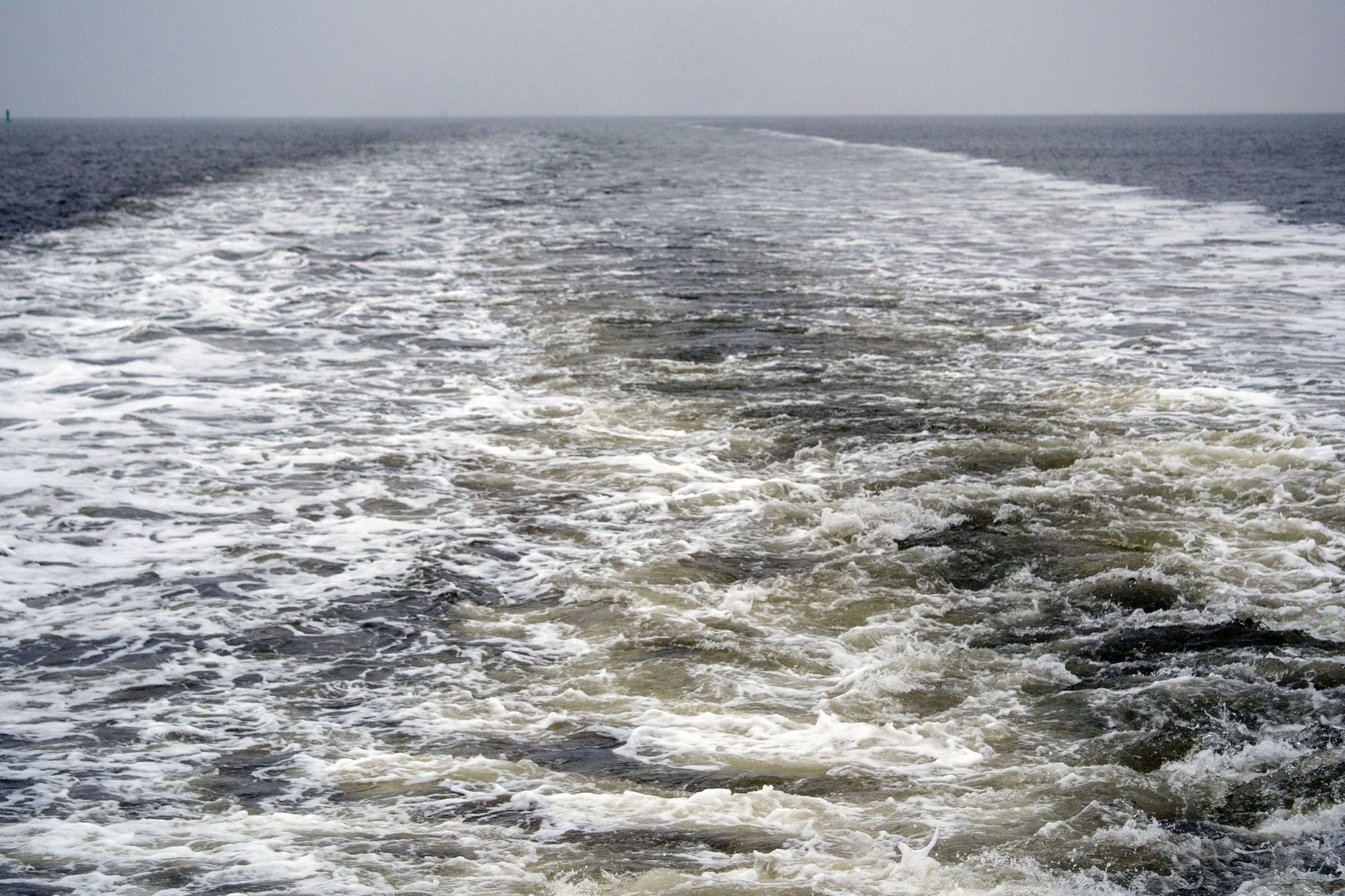 Das Wasser hinter dem Schiff wird durch den Antrieb aufgewirbelt.