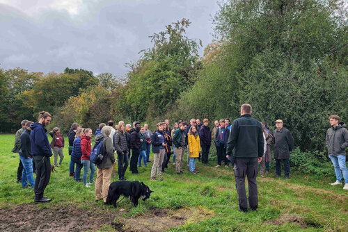 Excursion Project team on the excursion stands in front of a hedge