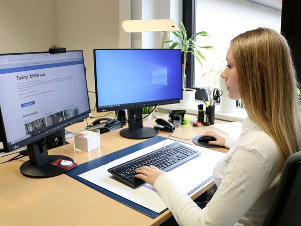 Auszubildende sitzt am PC in der Verwaltung.