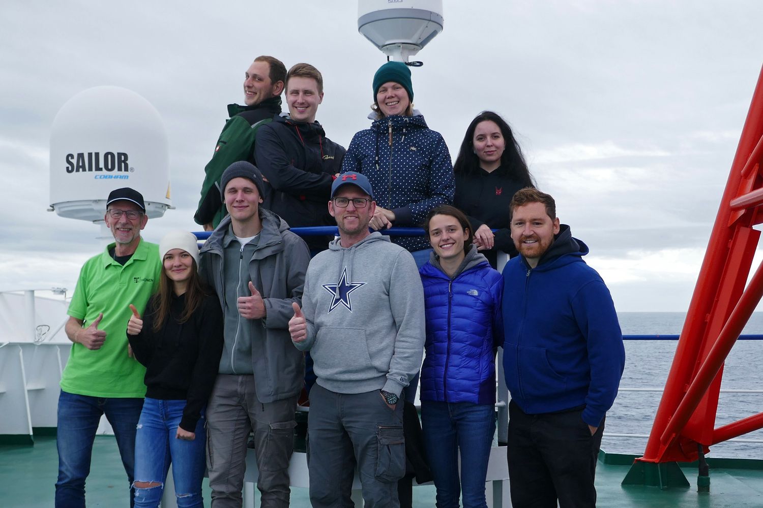 Unser Team auf dem Peildeck: Tim, Felix, Lea, Abigail (oben), Michael, Julia, Anton, Matthias, Nina, Jan (unten). Die zehn Fahrtteilnehmer possieren an Deck für ein Abschiedsfoto.